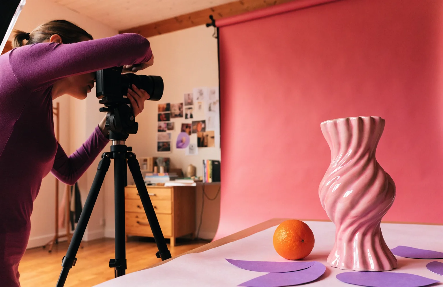 Illustratief sfeerbeeld van een creatieve fotoshoot met een roze decor.